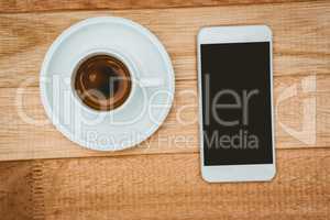 Above view of a coffee and a smartphone
