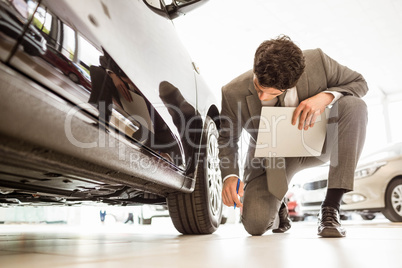 Focused businessman looking at the car body