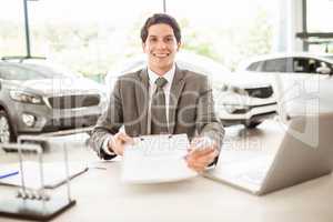 Smiling salesman holding a contract and a pen