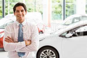 Smiling businessman standing with arms crossed