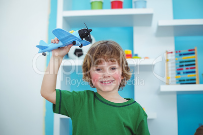 Small boy playing with a toy plane