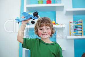 Small boy playing with a toy plane