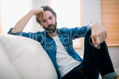 Unahppy man thinking on his sofa