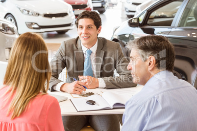 Smiling couple buying a new car