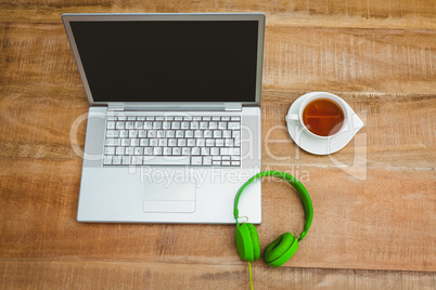 View of a grey laptop with a green headphone