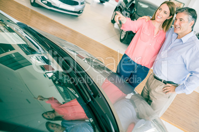 Couple talking together while looking at car