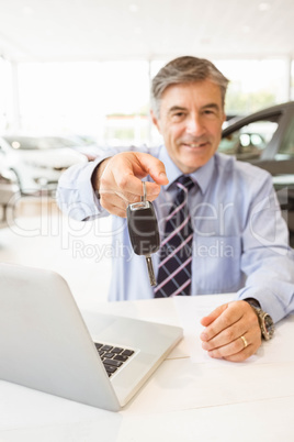 Smiling salesman holding a customer car key