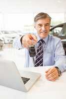 Smiling salesman holding a customer car key