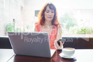 Mature student using laptop in cafe