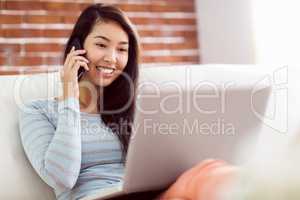 Asian woman on the phone using laptop