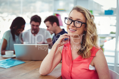 Smiling creative businesswoman working with co-workers