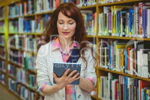 Mature student in the library using tablet