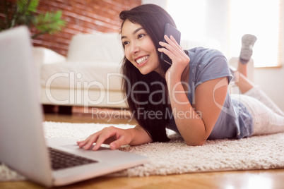 Asian woman using laptop on floor