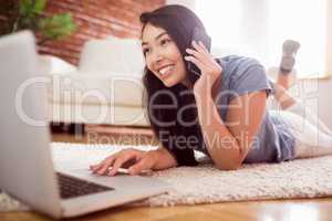 Asian woman using laptop on floor