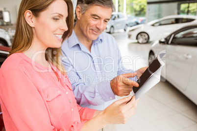 Smiling couple choosing the color of their new car