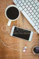 Coffee and white smartphone with headphones