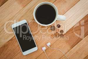 Coffee and white smartphone with white headphones