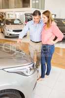 Couple talking together while looking at car