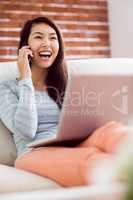 Asian woman on the phone using laptop