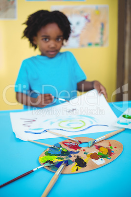 Happy kid painting on a sheet