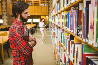 Hipster student picking a book in library