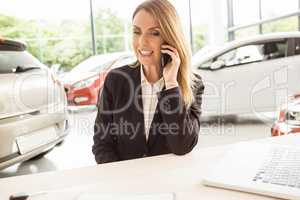 Smiling saleswoman having a phone call