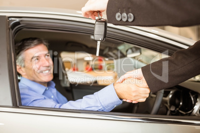 Customer receiving car keys while shaking hand