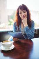 Mature student using tablet in cafe