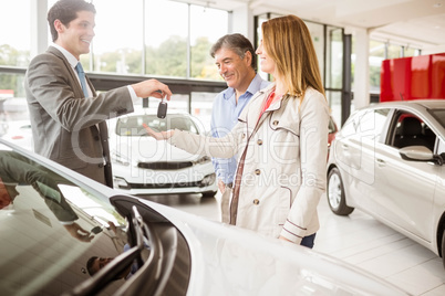 Salesman giving car key to a couple Salesman giving car key to a couple