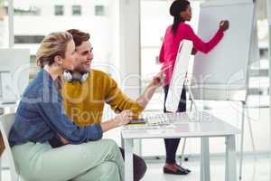 Graphic designer wearing headphones at desk