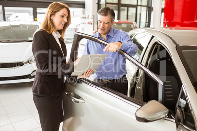 Smiling businessman undersign a car contract