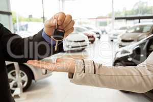 Salesman offering car key to a customers