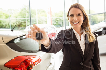 Smiling saleswoman holding car key