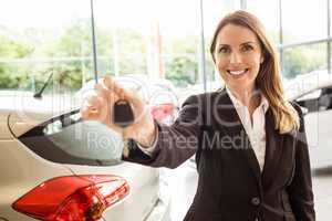 Smiling saleswoman holding car key