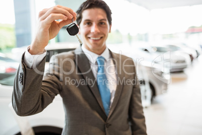 Salesman standing while offering car keys