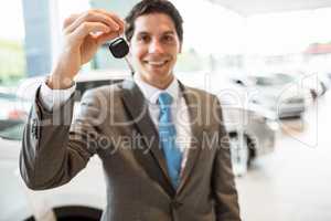 Salesman standing while offering car keys