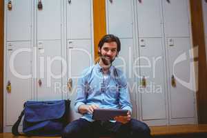 Hipster student using tablet in hallway