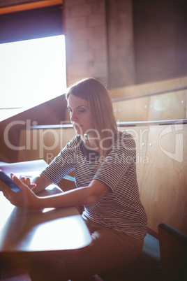 Mature student in lecture hall using tablet