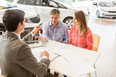 Smiling couple buying a new car