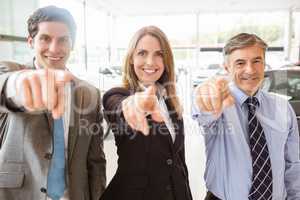 Group of smiling business team pointing together