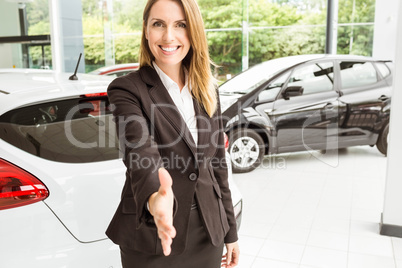 Smiling saleswoman ready to shake hand