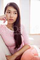 Upset asian woman on couch