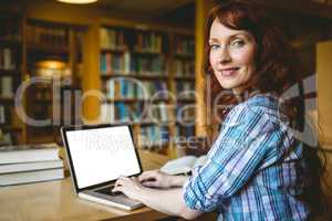 Mature student studying in library with laptop