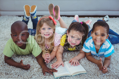 Happy kids reading a book together