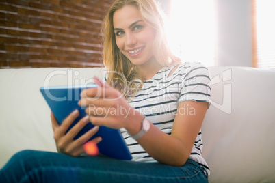 Pretty blonde using tablet on couch