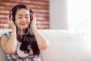 Asian woman on the couch listening to music