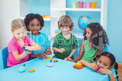 Smiling kids playing with modelling clay