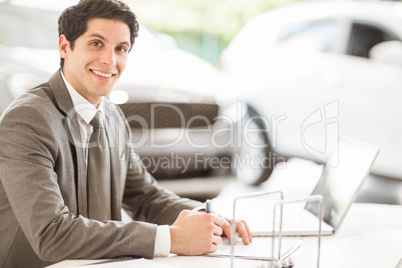 Smiling salesman at his desk