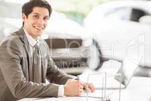 Smiling salesman at his desk
