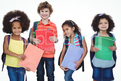 A row of children standing together with school bags